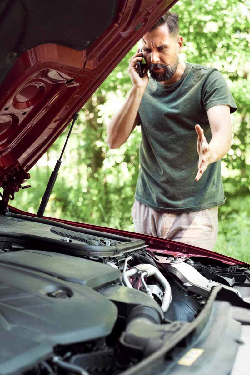 Junger Mann prüft Getriebeschaden bei Schrottauto Ankauf Lemgo